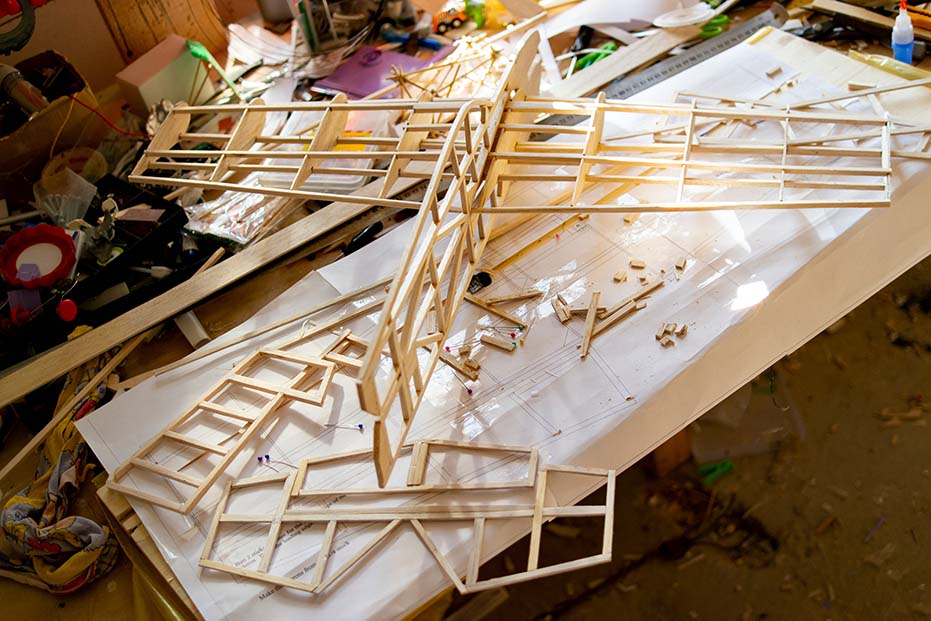 Wooden frame parts of a model airplane under construction using wood glue