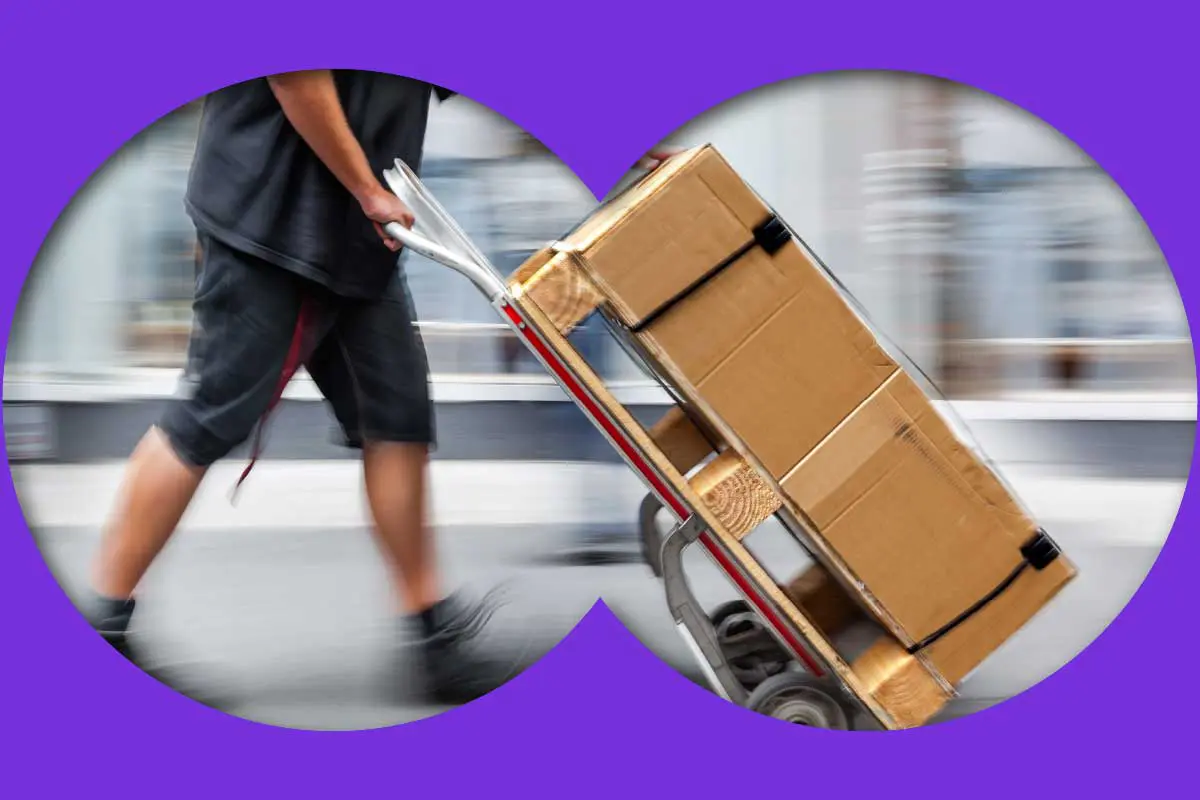 Building materials with free delivery being moved using a dolly by a delivery driver