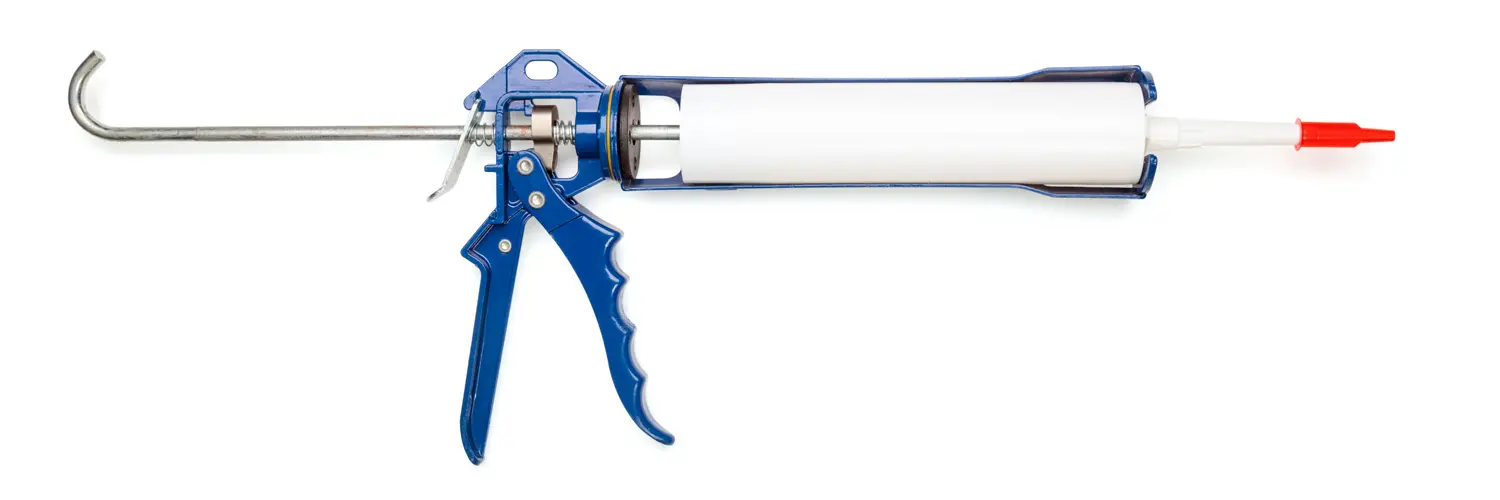 Blue metal sealant gun with attached white plastic cartridge