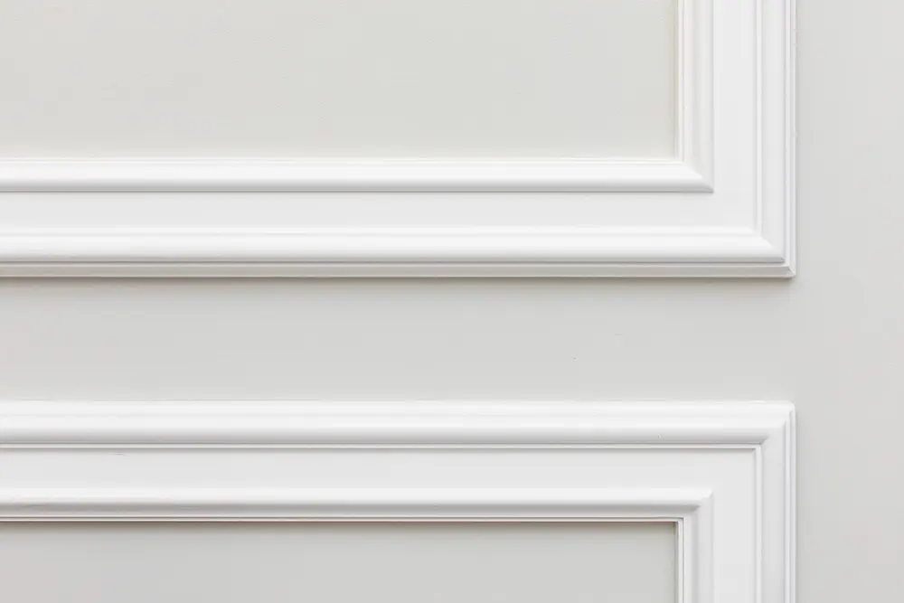 Close-up detail of white interior mouldings with gaps filled using decorators caulk.Â