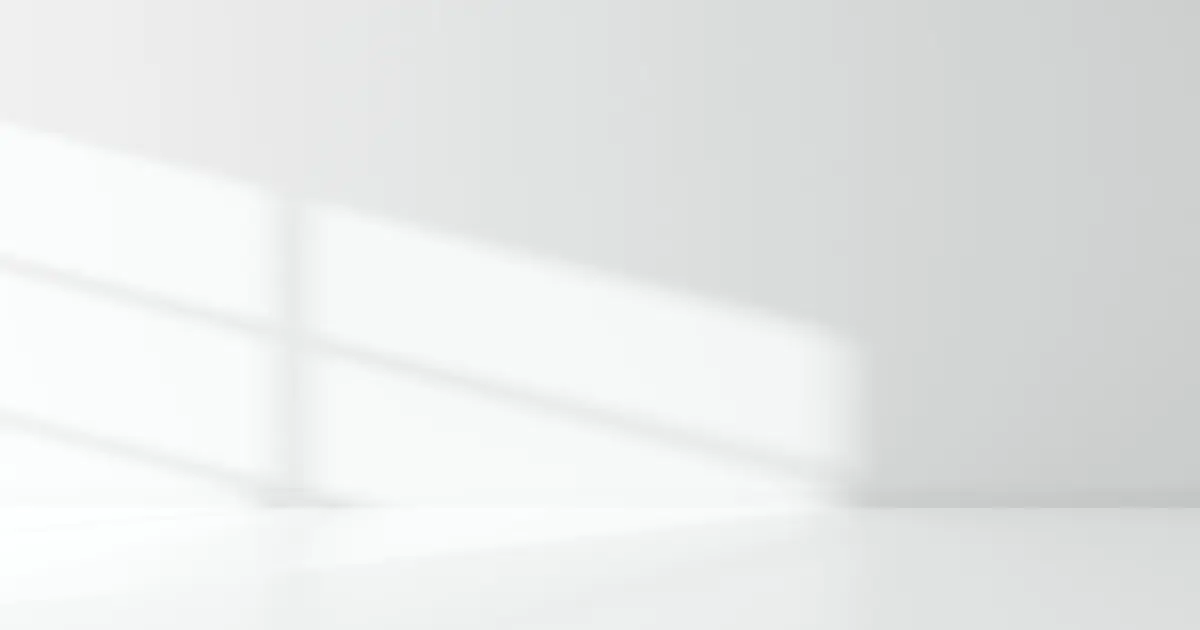 Consider The Ambient Lighting A minimalist study of light and shadows, showing a soft window pane shadow cast onto a clean, empty white wall and floor