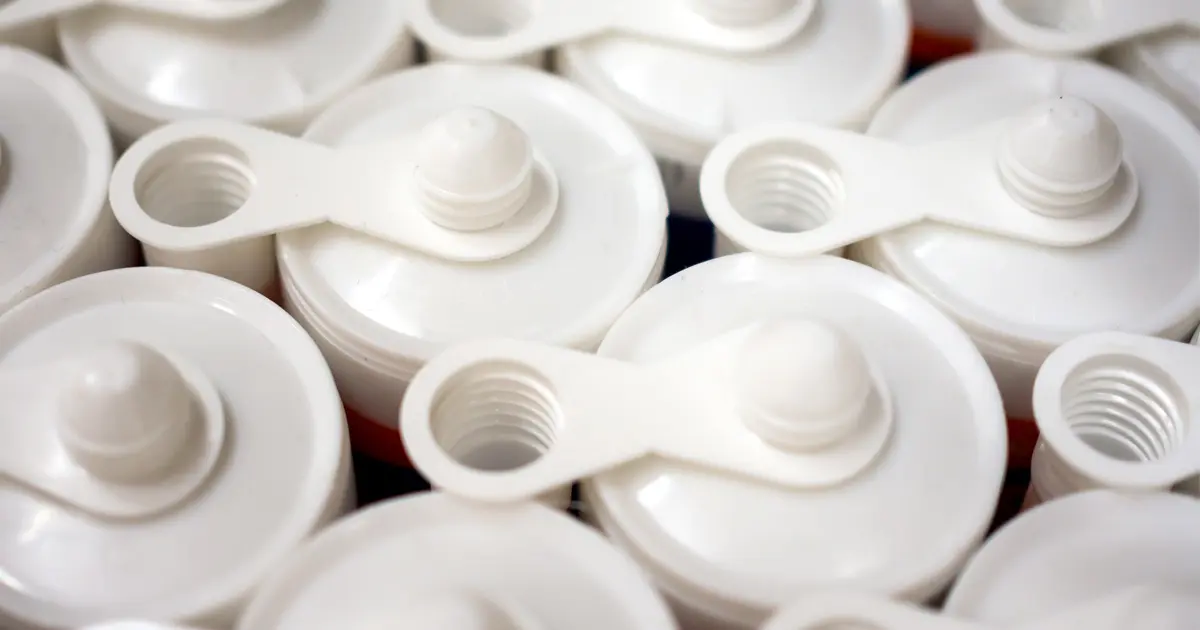Choosing The Best Silicone Sealant Close-up of several white sealant cartridges and nozzles for home repair and waterproofing.